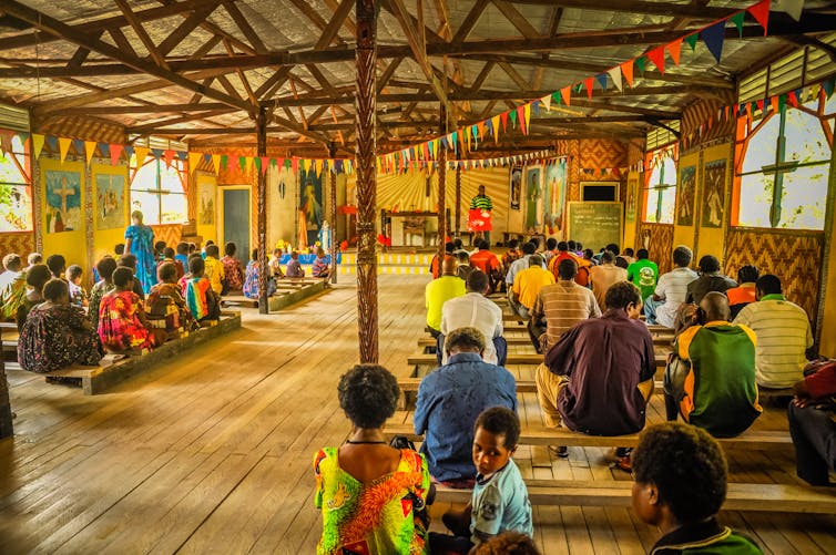 villagers sit in hall