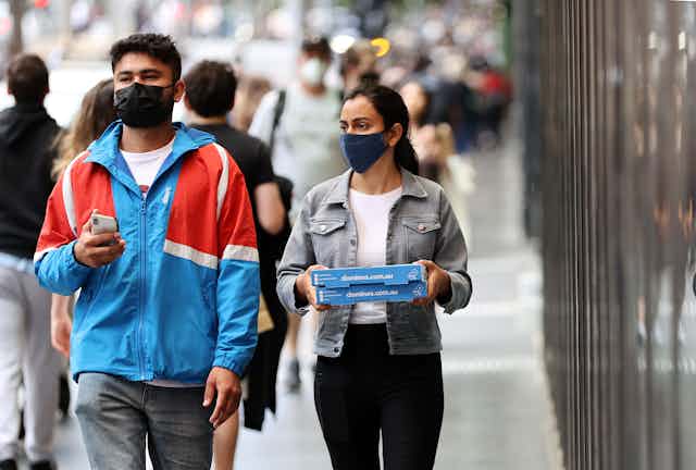 People wearing masks walking down the street