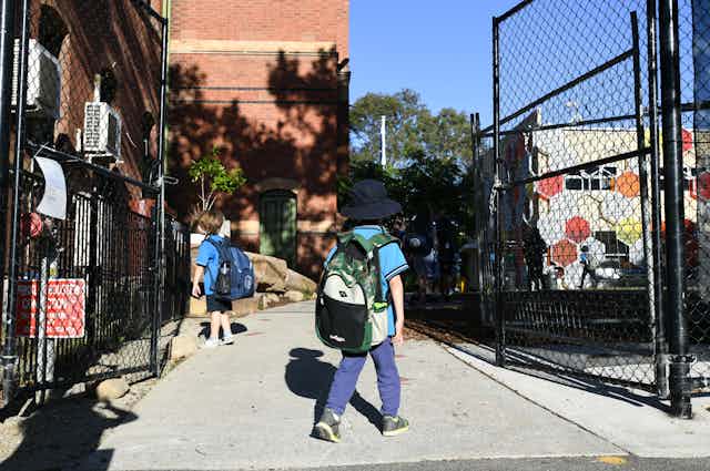 A child walks through a school gate