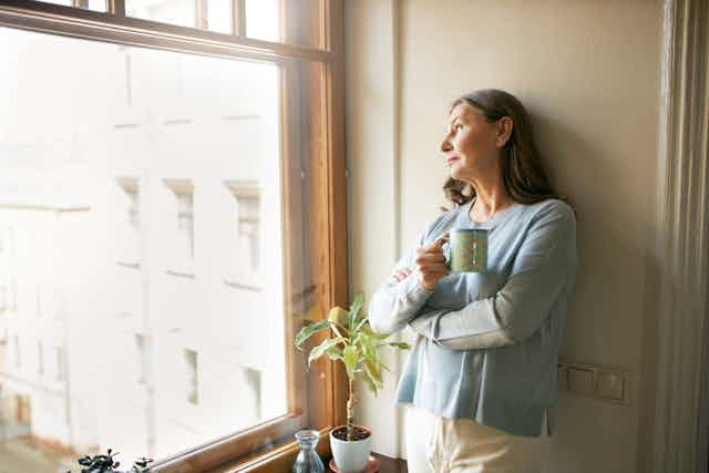 A woman looks pensively out the window.