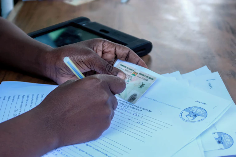 Elections official writing on registration form.