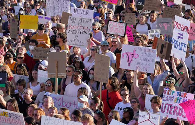 A crowd of people holding various anti-abortion signs