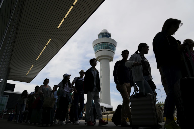 Des personnes font la file, avec des bagages