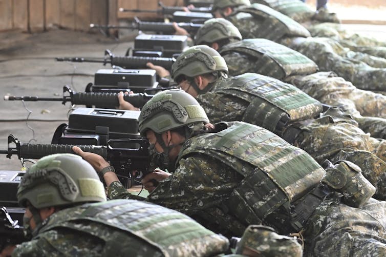 Hommes en tenue de camouflage couchés en train de tirer à la mitraillette