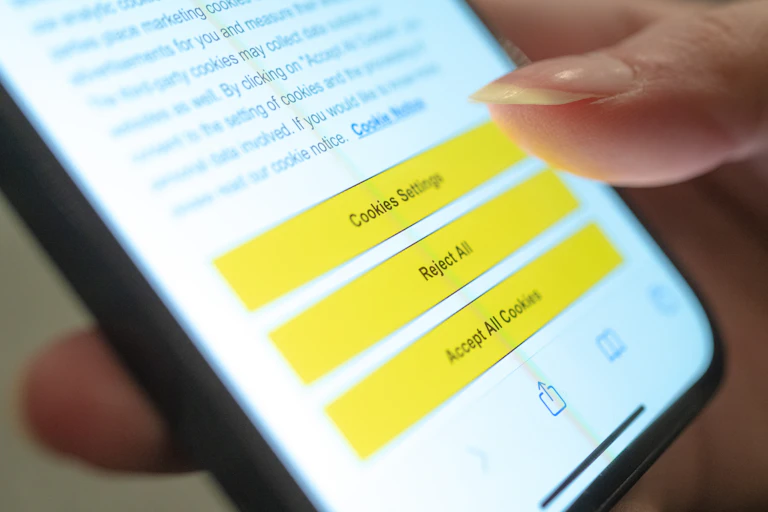 a hand holding a smart phone with the screen displaying text and three buttons