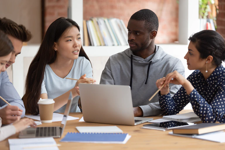 Young people in discussion around a desk