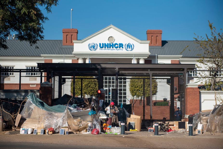 Refugees take shelter in front of the UN refugee centre in South Africa. 