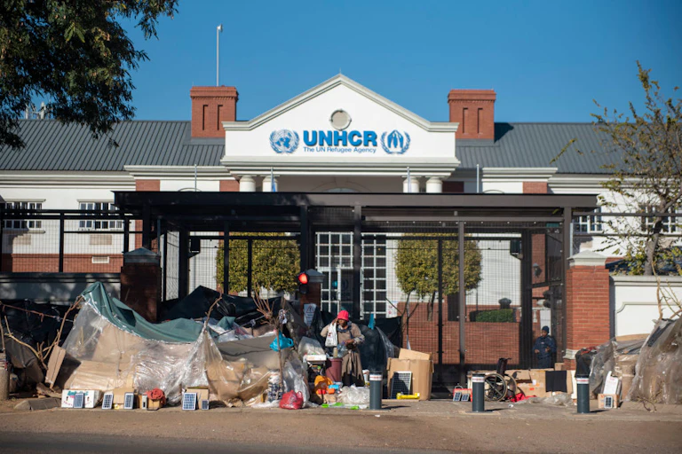 Refugees take shelter in front of the UN refugee centre in South Africa.