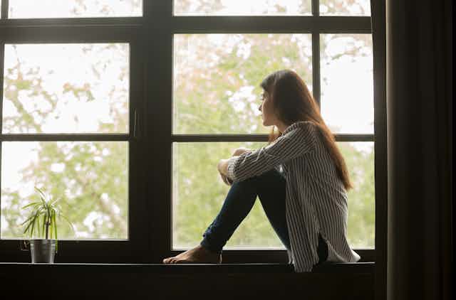 Image of a woman looking out the window.