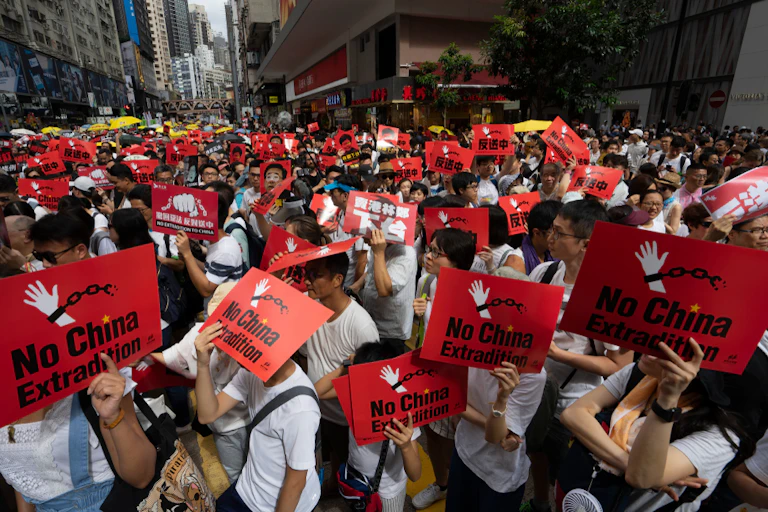 People carrying red placards in a protest.