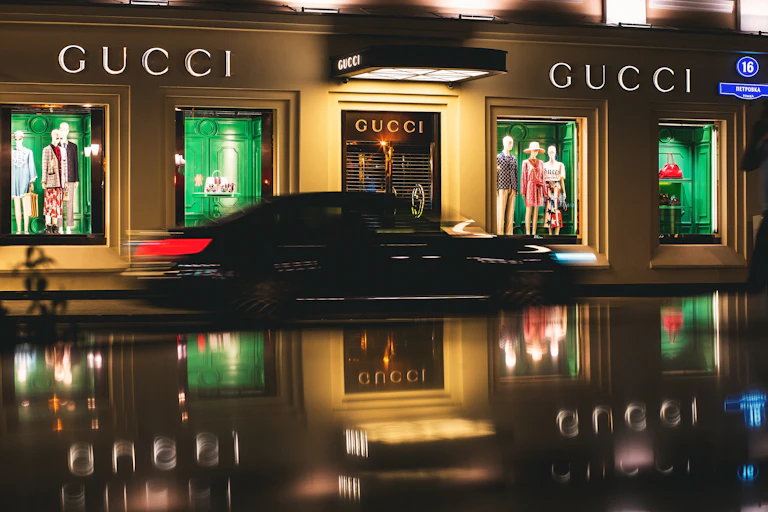 Image of a Gucci store at night as a car drives by
