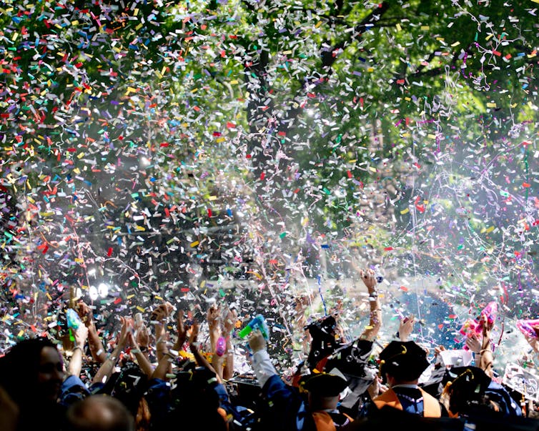 Tickertape falls on a student commencement crowd.