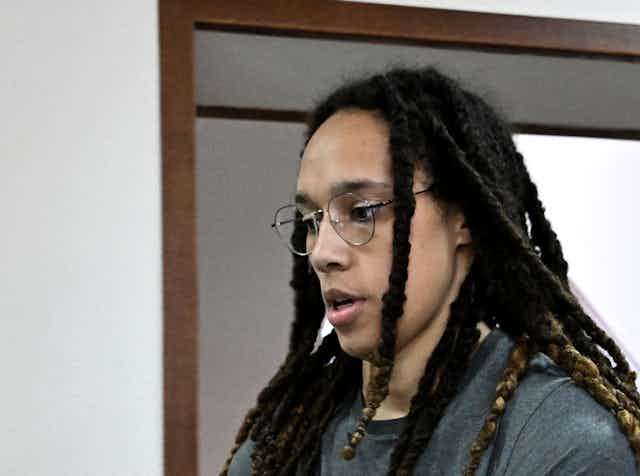 A black woman in handcuffs is looking down as she appears in court