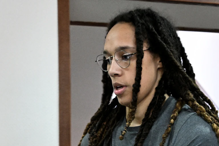 A black woman in handcuffs is looking down as she appears in court