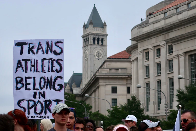 A sign reads 'trans athletes belong in sport'