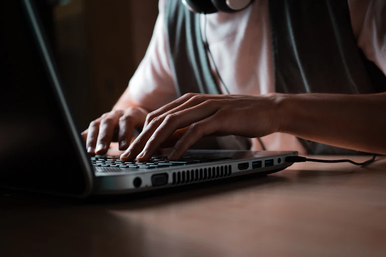 Hands typing on a laptop keyboard