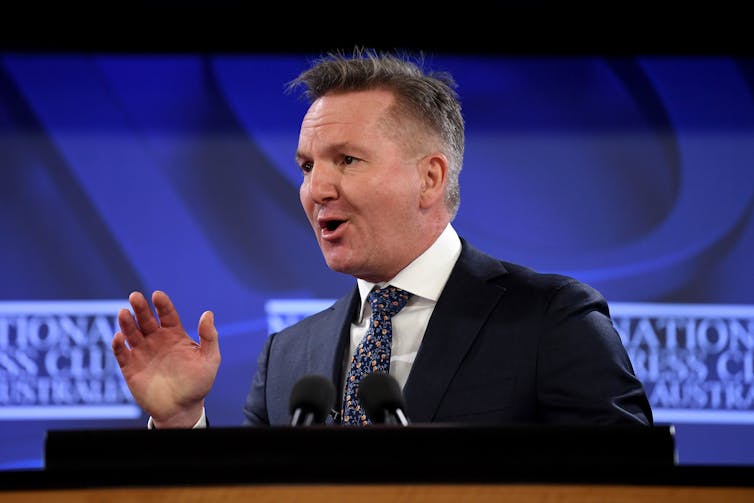 man in suit talking at lectern