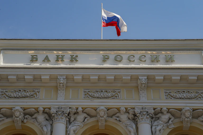 Russian National flag above the sign for 'Bank of Russia' on the Russia's Central Bank headquarters in Moscow, Russia