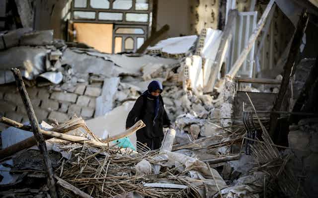 Femme au milieu des débris, suite à un séisme.