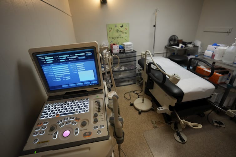 An abortion procedure room with a computer screen and a medical bed