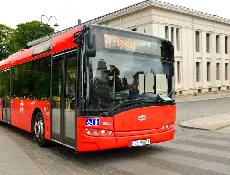 a red bus on a city street