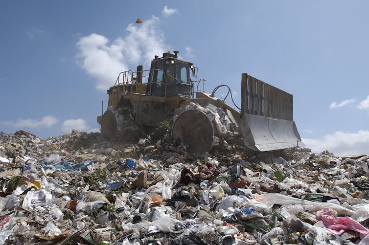 Bulldozer pushing rubbish in a landfill