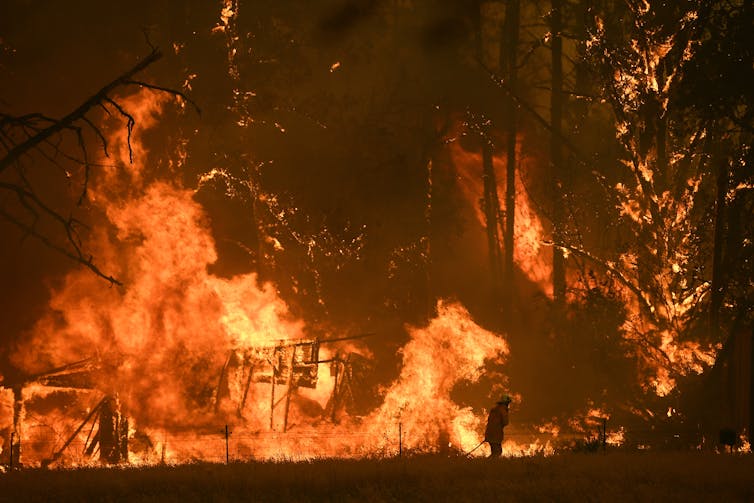 person silhouetted against flames