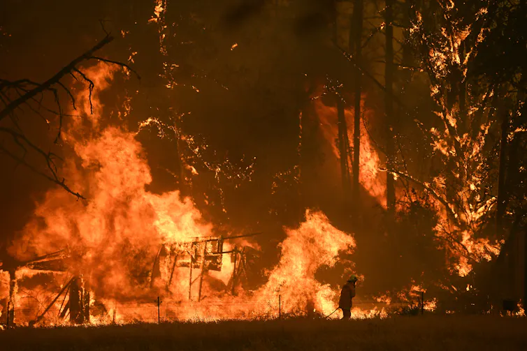 person silhouetted against flames