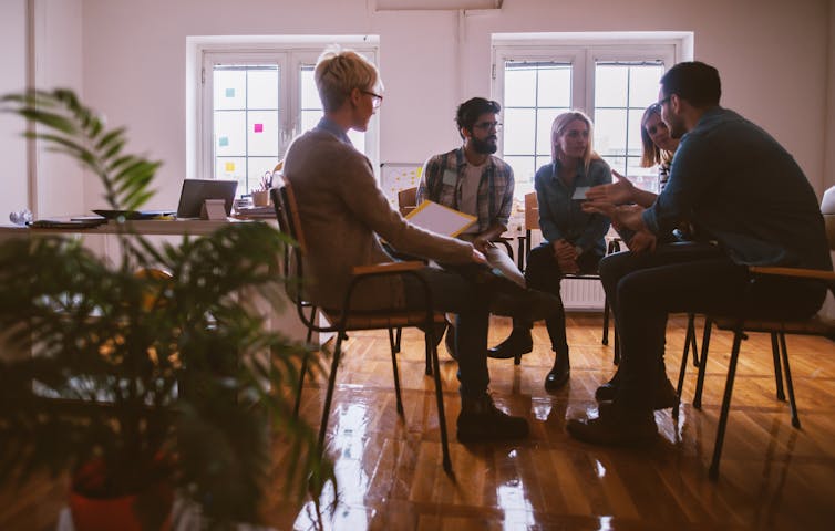 People in a room sitting on chairs in a circle