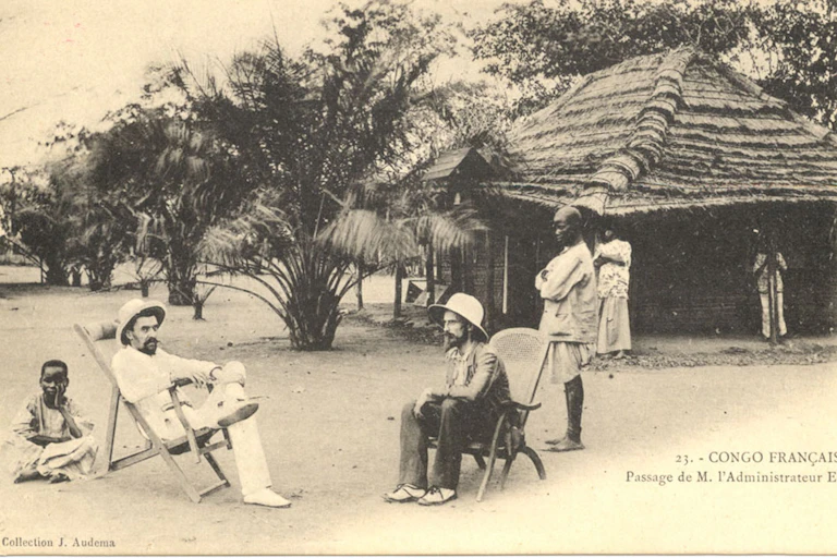 Photo en noir et blanc montrant des administrateurs coloniaux dans un village africain au début du XXe siècle