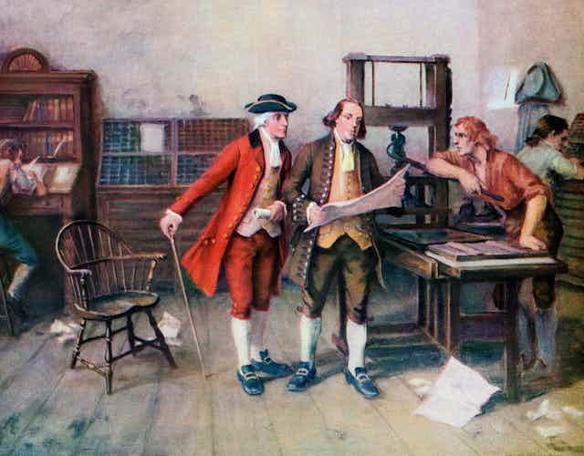 Three 18th century men in a room filled with books along the wall, looking at a large piece of paper.