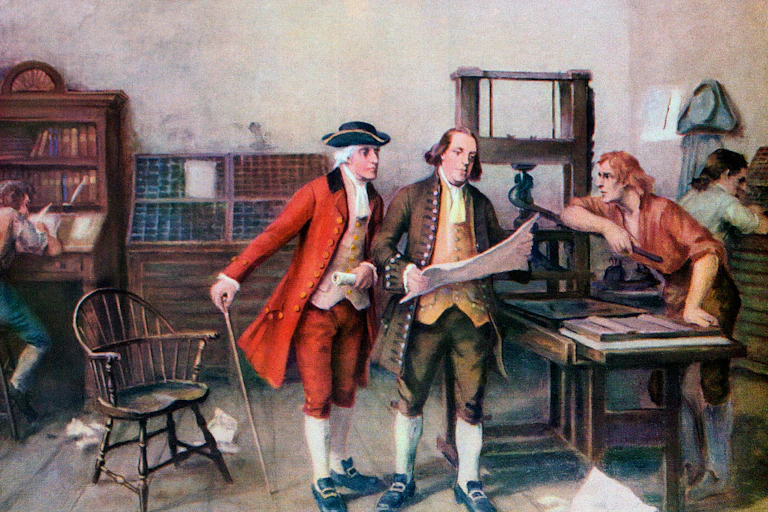 Three 18th century men in a room filled with books along the wall, looking at a large piece of paper.