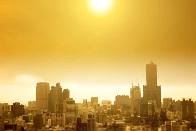Bright orange sunlight descends on a city depicting a heat wave.