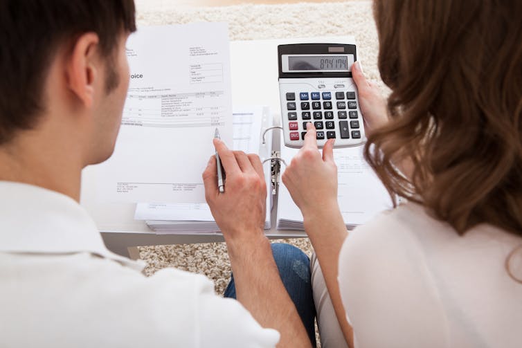Man and woman with paperwork and calculator