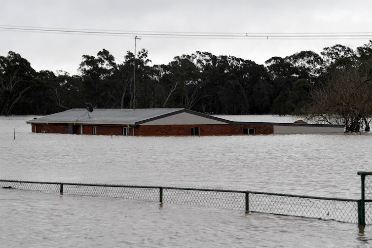 A house submerged in floodwater up to the roof