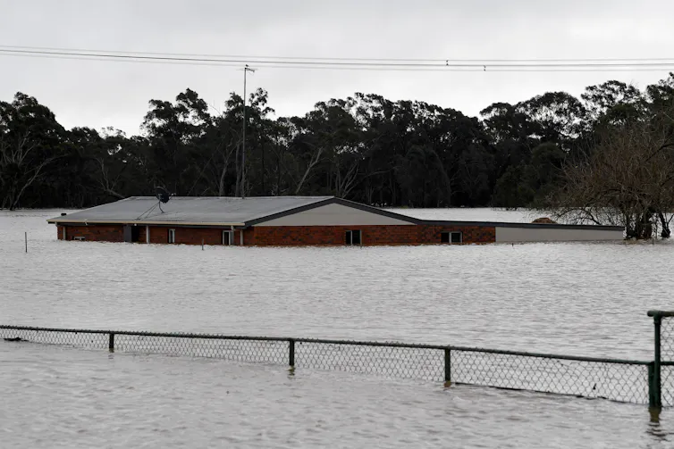 A house submerged in floodwater up to the roof
