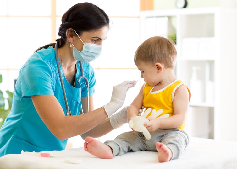 Krankenschwester impft Kleinkind