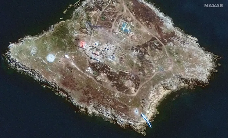 A handout satellite image made available by Maxar Technologies shows smoke can be seen from burning vehicles/structures at several locations across the northern section Snake Island.