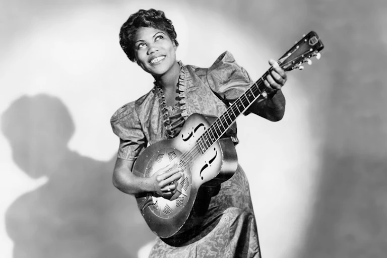 Black female singer with a guitar.