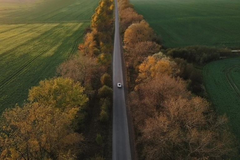 Aerial view of single car on country road.