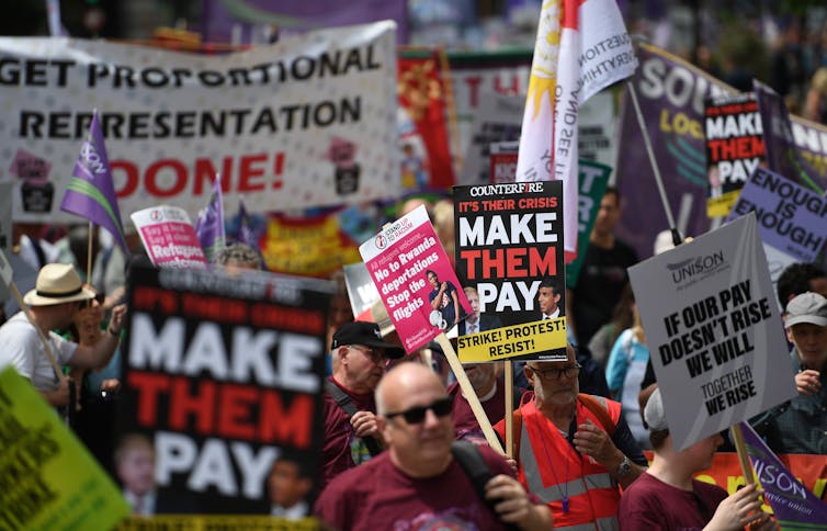 Crowd of people and signs protesting cost of living crisis