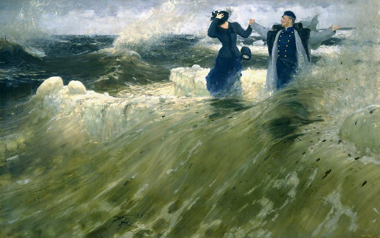 Un homme et une femme jouent et rient, habillés dans une grande vague