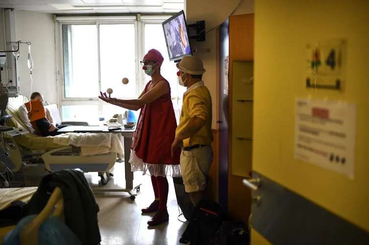Un enfant reçoit la visite de clowns dans sa chambre à l’hôpital
