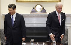 Joe Biden und Xi Jinping stehen sich in einem Raum gegenüber.