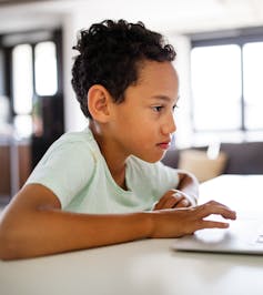 A child in front of a laptop.