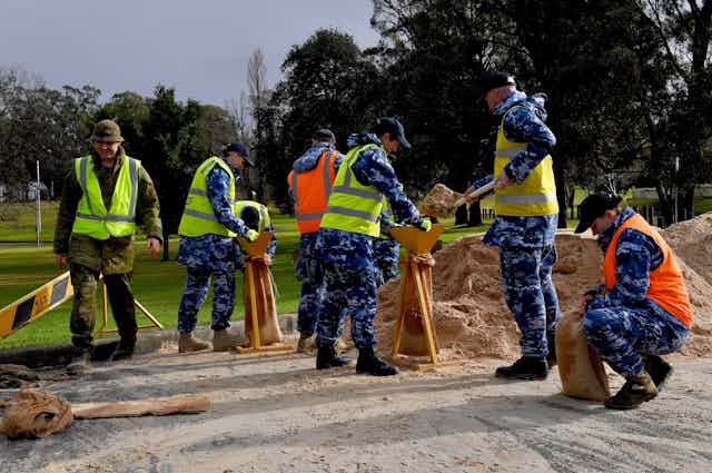 Defence personnel fill sandbags