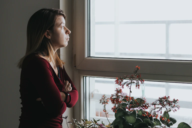 A woman looks pensively out the window.