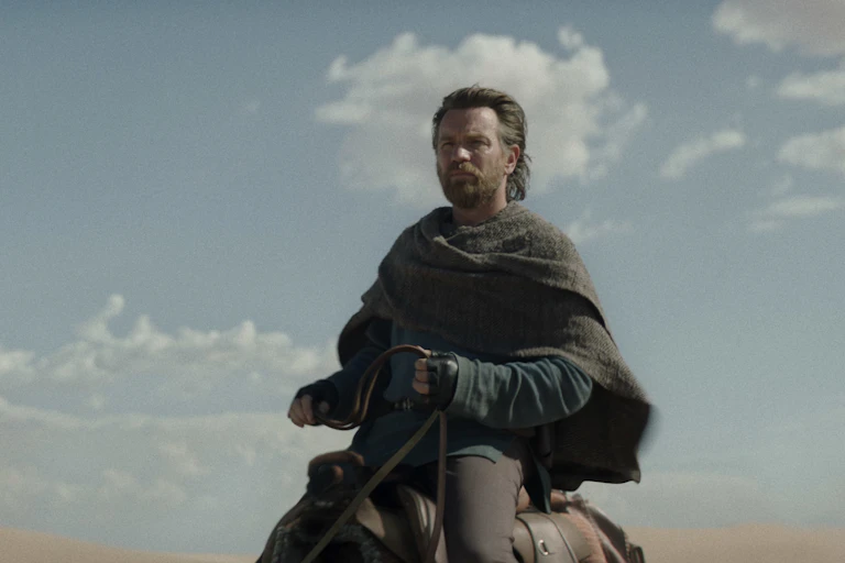 Man riding an animal in the desert.