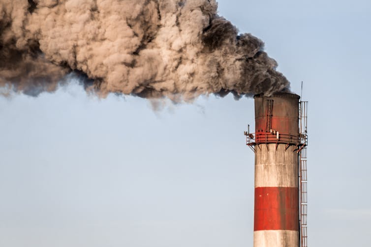 A striped chimney belching sooty smoke.