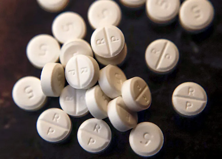 White pills scattered on a black background